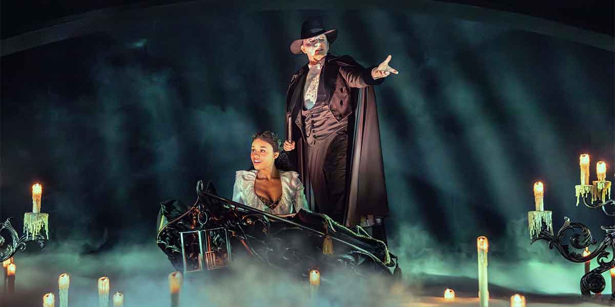 Dean Chisnall and Beatrice Penny-Touré perform on stage, surrounded by candles and misty lighting.