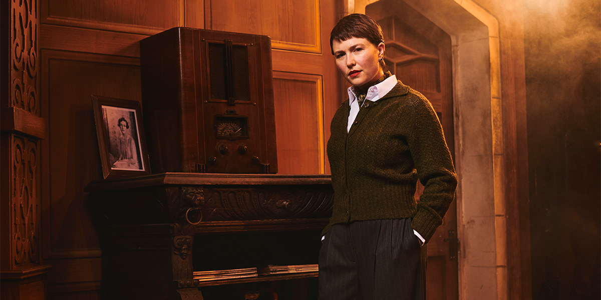 A scene from "The Mousetrap" featuring actors in period costumes on stage, with dramatic lighting.