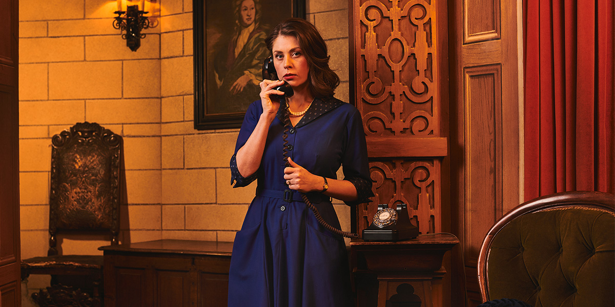 A scene from "The Mousetrap" featuring actors on stage, with dramatic lighting and a detailed set design.