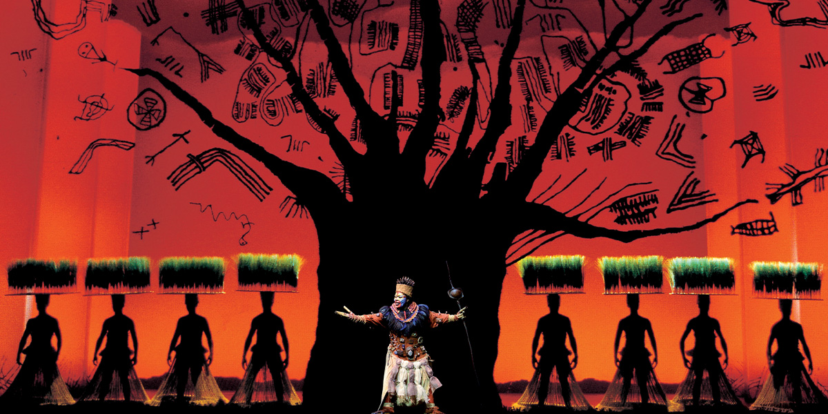 A vibrant tree with intricate branches and leaves, set against a bright blue sky in Disney's The Lion King.