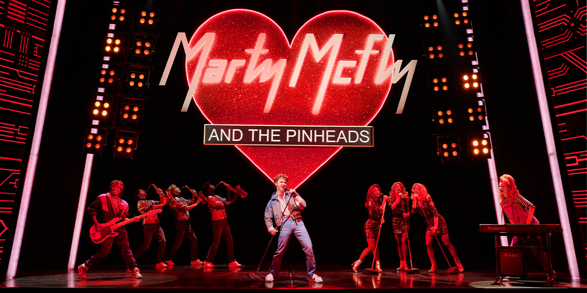 Caden Brauch as Marty McFly performs energetically with a group of actors on a vibrant stage.