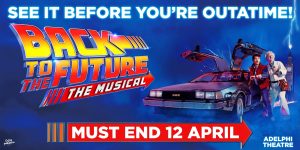 A scene from Back To The Future The Musical featuring characters in vibrant costumes, with a dynamic stage backdrop.