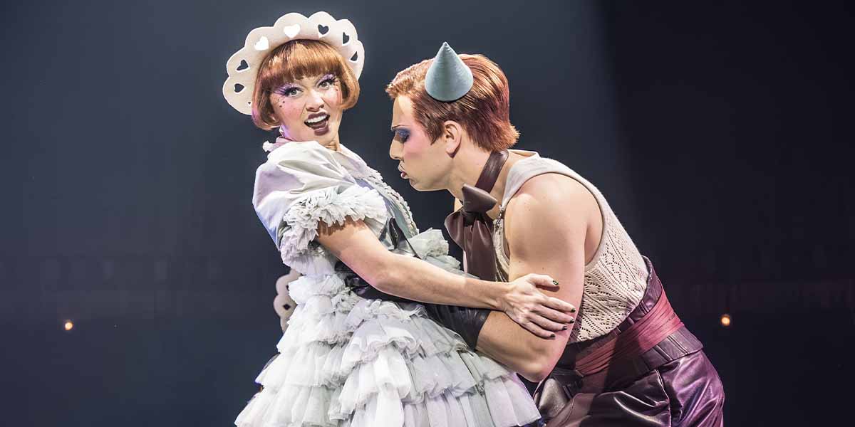 Sarah Hyland as Sally Bowles and Skylar Astin as Emcee perform together, dressed in vibrant costumes.