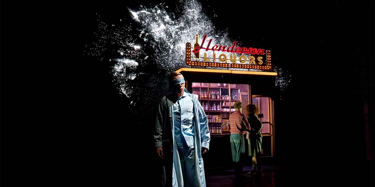 A man in a blue robe stands in front of "Henderson Liquors," with two figures conversing nearby.