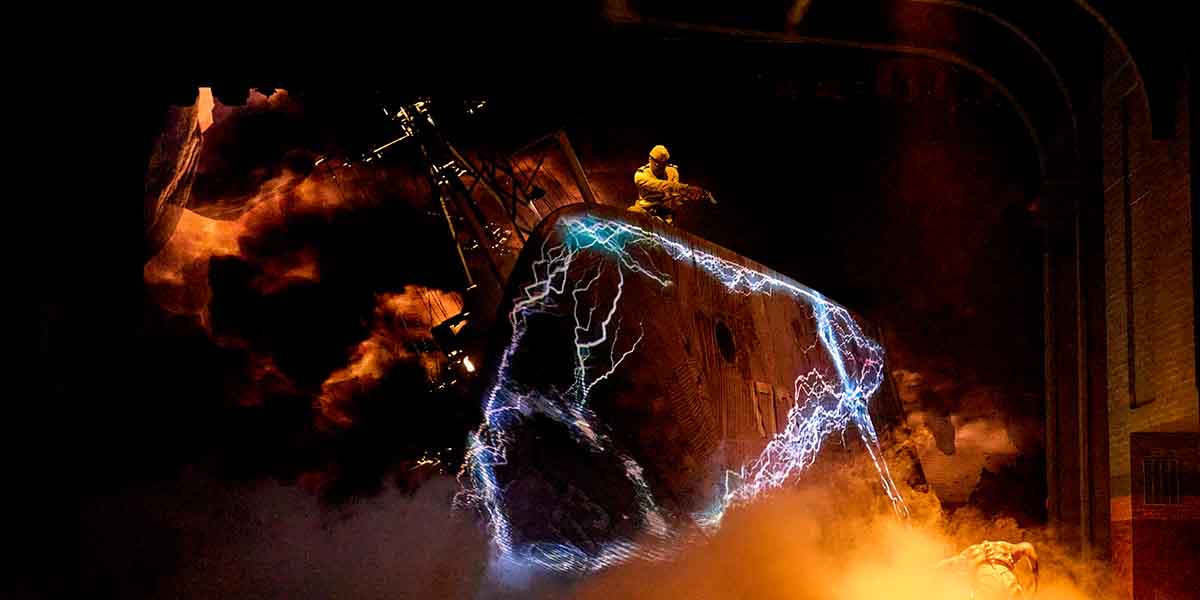 A figure in yellow sits atop a tilted ship, surrounded by swirling smoke and electric blue lightning.