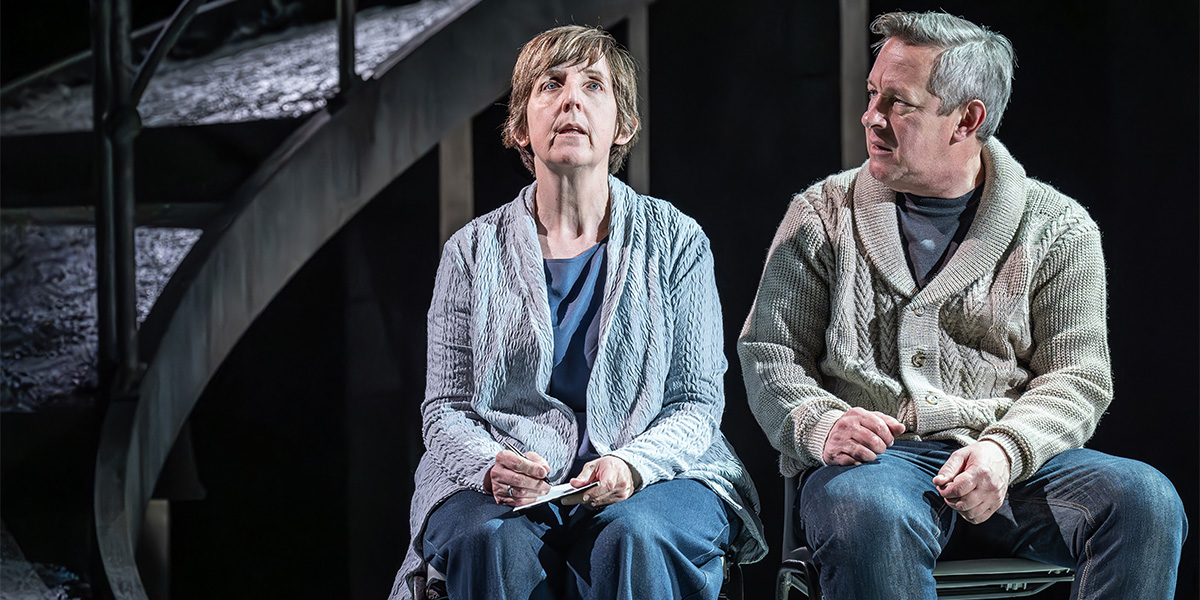 Julie Hesmondhalgh and Tony Hirst perform on stage, with dramatic lighting highlighting their expressions and costumes.