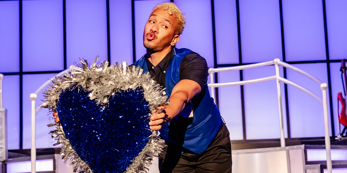 A detailed close-up of a vintage ship model, showcasing intricate craftsmanship and a dark wooden base.