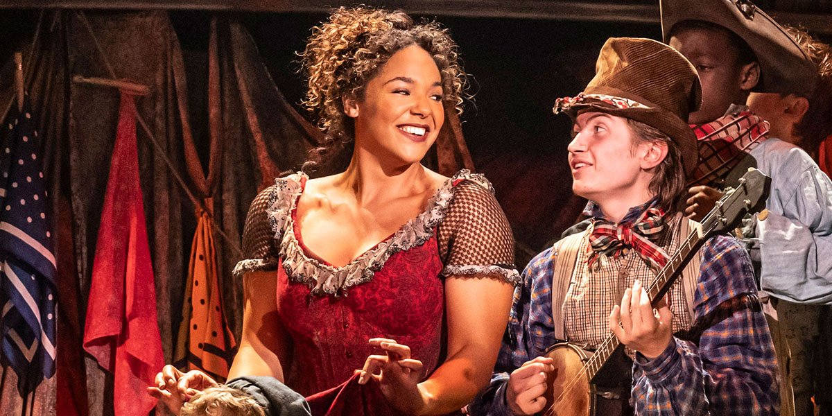 Oliver Shanay Holmes and Billy Jenkins perform on stage, dressed in colourful costumes, with dramatic lighting.