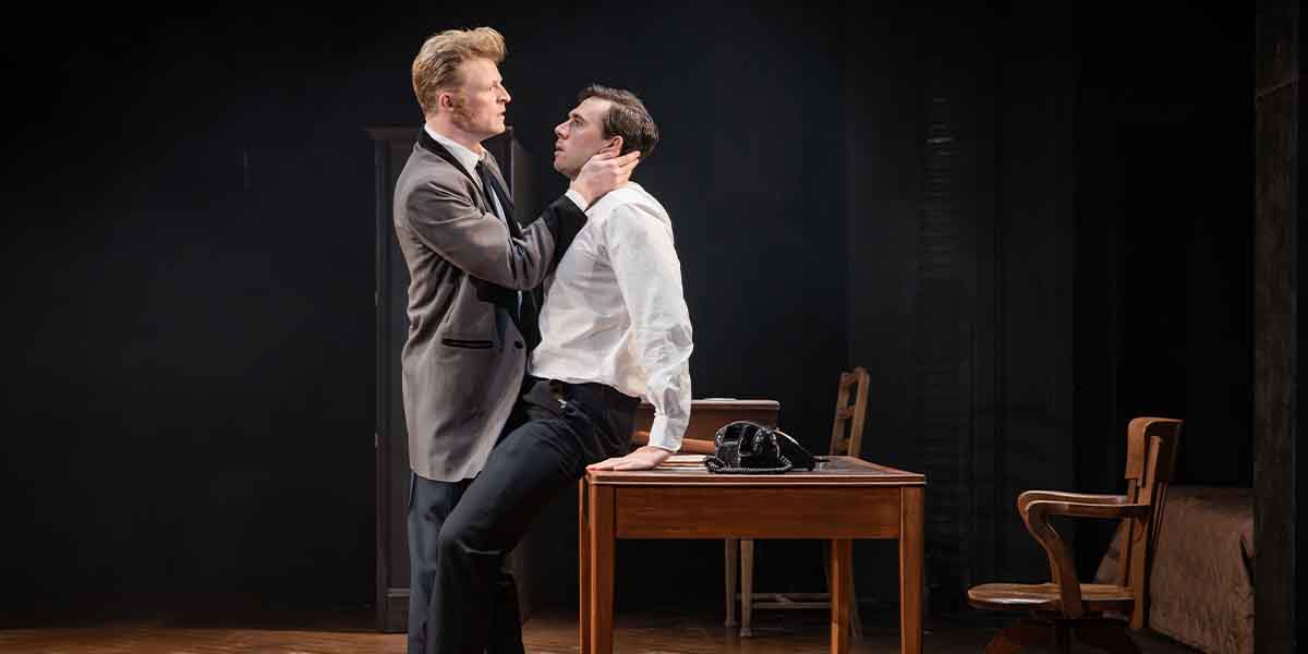 William Robinson and Calam Lynch in a tense scene, with Robinson gripping Lynch's collar, at a desk.