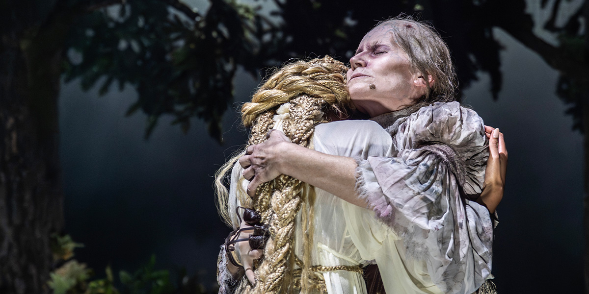 Two people one with long golden hair embrace.