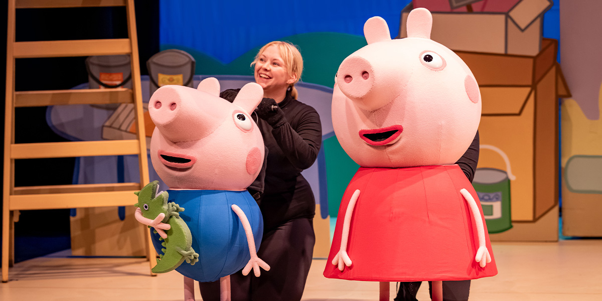 George and Peppa Pig, animated characters, are smiling and posing together in a vibrant, colourful setting.