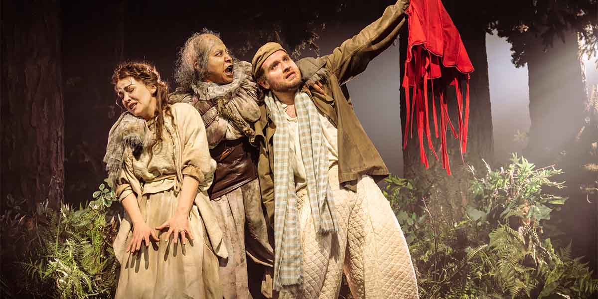 Rachel Tucker, Melanie La Barrie, and Hughie O'Donnell perform in "Into The Woods," surrounded by foliage.