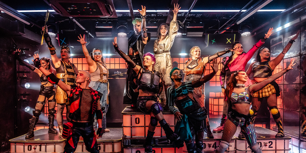 A group of elegantly dressed individuals seated at a round table, enjoying a meal in a sophisticated restaurant setting.