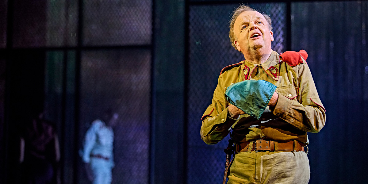 David Harewood as Othello and Toby Jones as Iago, both in dramatic poses, on a dimly lit stage.