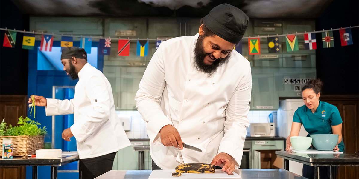 Five individuals stand together, smiling, dressed in casual attire, with a bright outdoor background.
