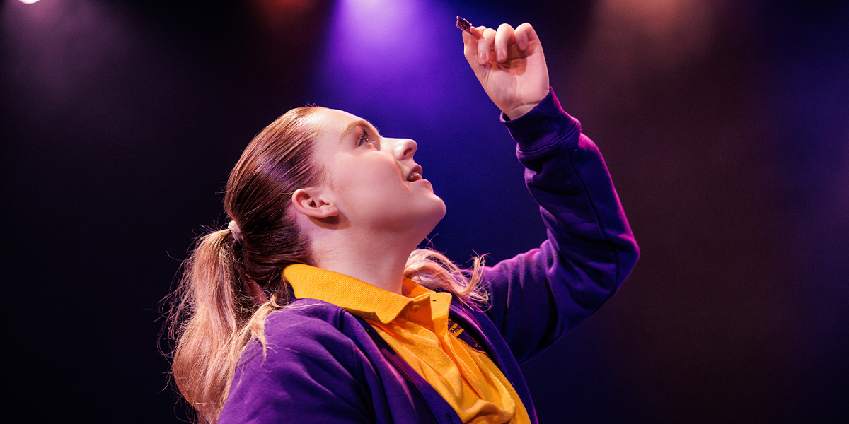 A group of diverse individuals in casual attire, smiling and interacting around a table with games.