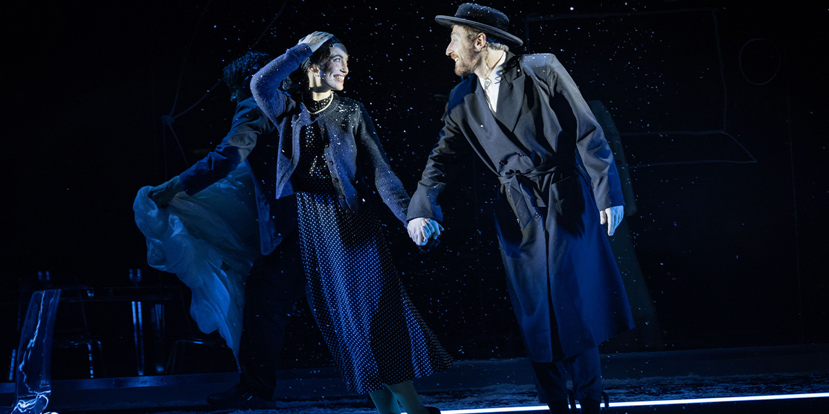 Katerina Tannenbaum as Esther and Eddie Toll as Schmuli, both in period costumes, on a stage set.