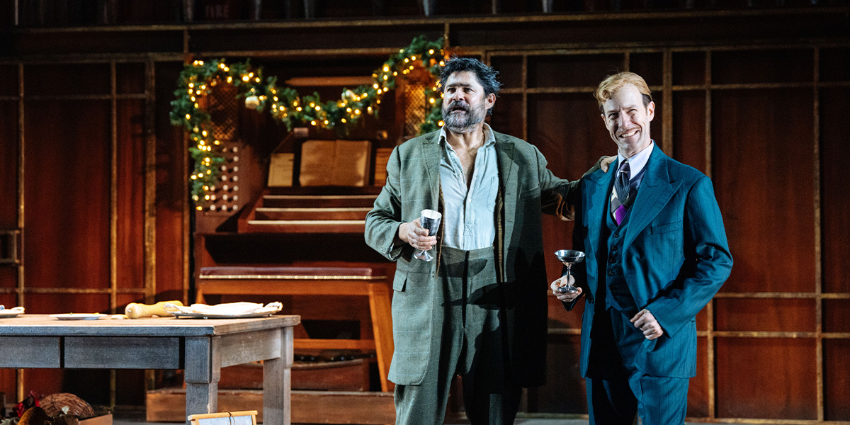 A scene from Twelfth Night featuring actors in period costumes on stage, with vibrant set design and lighting.