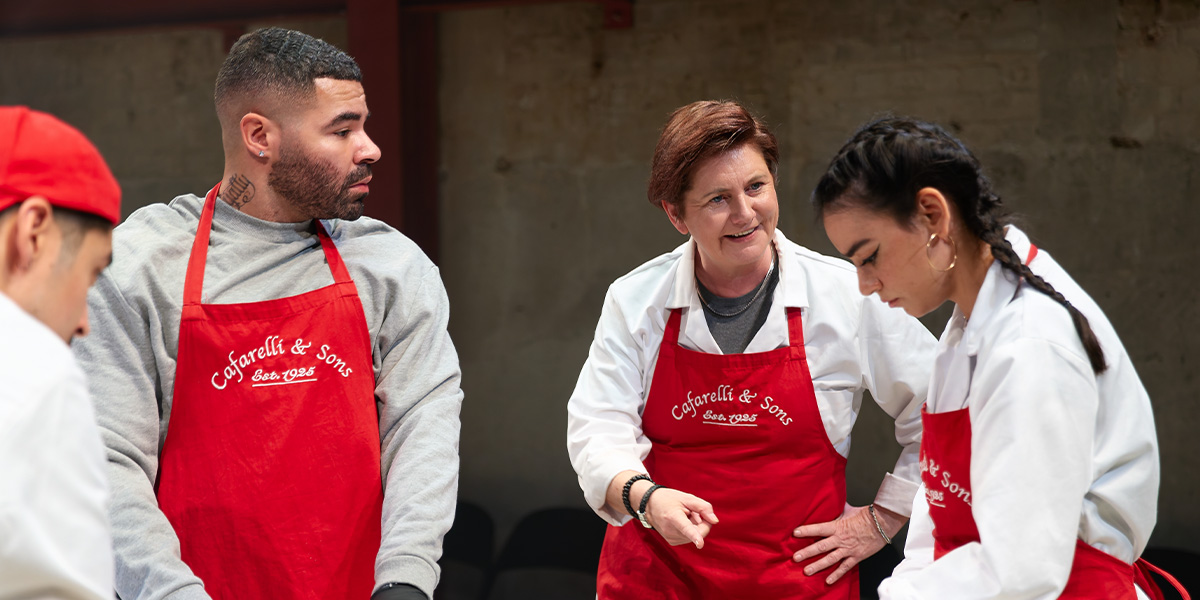 Ash Hunter as Billy, Jackie Clune as Paula, and Mithra Malek as T pose together, smiling.