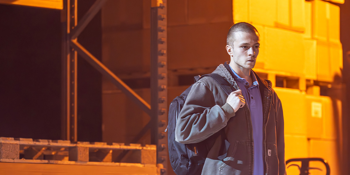 A group of people in formal attire stands on a stage, with a spotlight illuminating them against a dark background.
