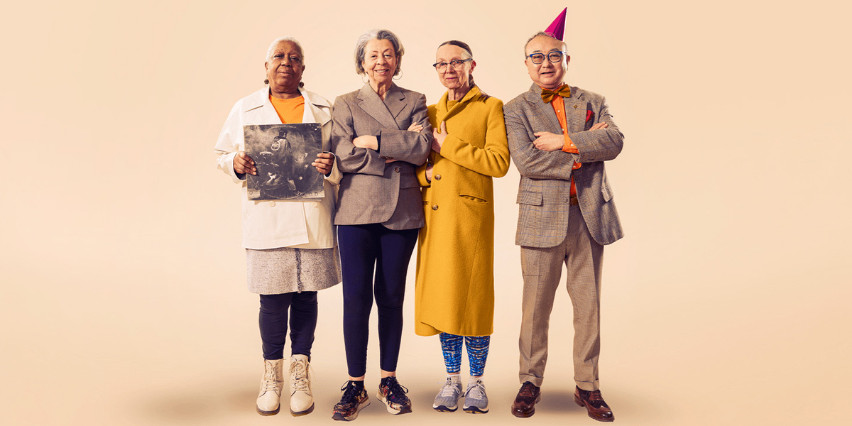 Four individuals standing side by side, each showcasing unique personal styles, holding different items like an LP record and wearing a party hat against a pale background.