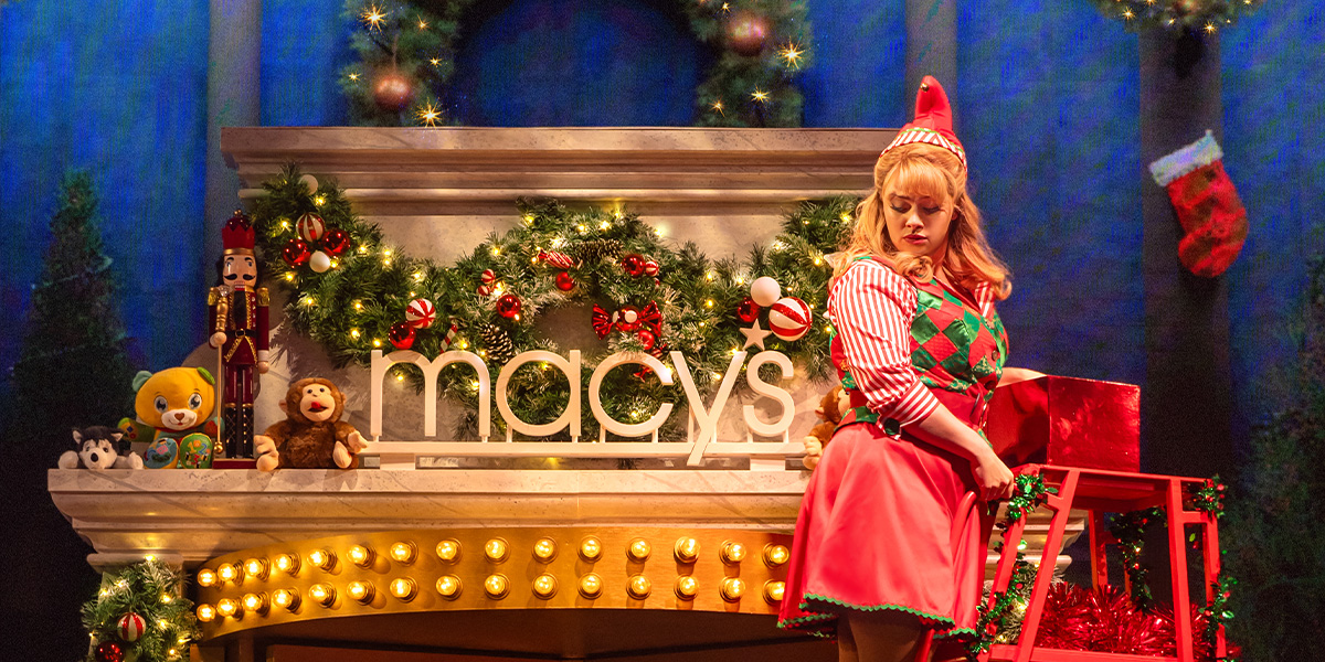 Joel Montague as Buddy and Carrie Hope Fletcher as Jovie perform together in festive costumes on stage.