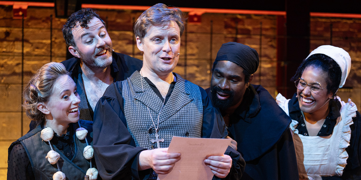 People stand on stage looking at a sheet of paper.