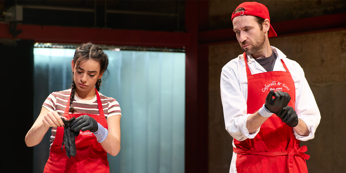 Mithra Malek and Eugene McCoy pose together, smiling, against a backdrop featuring The Meat Kings! logo.