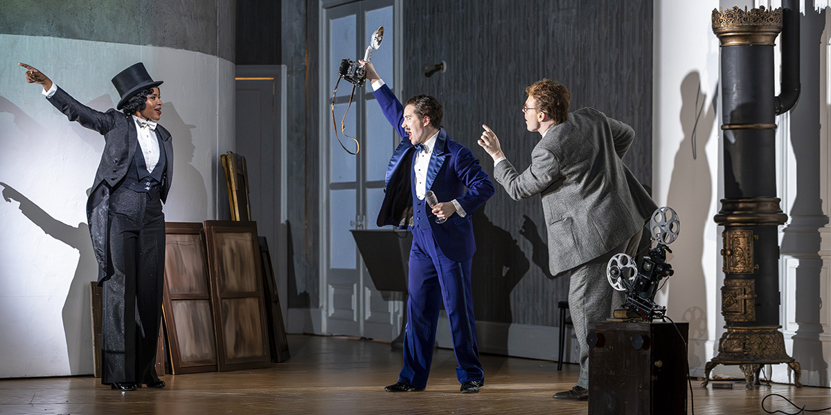 Nardus Williams, Jake Ingbar, and Ru Charlesworth pose together, dressed in period costumes, against a theatrical backdrop.