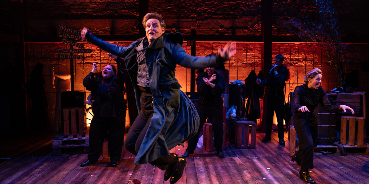 A person jumps in the air. Orange lighting can be seen in the background.