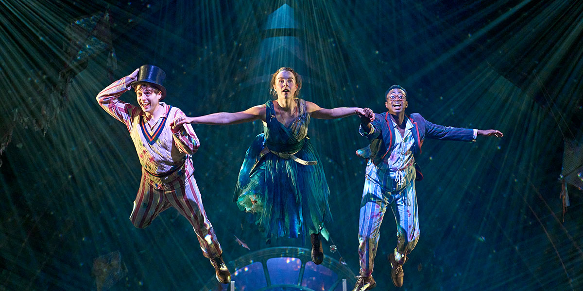 Wendy and Peter Pan are flying together against a starry night sky, surrounded by soft clouds.