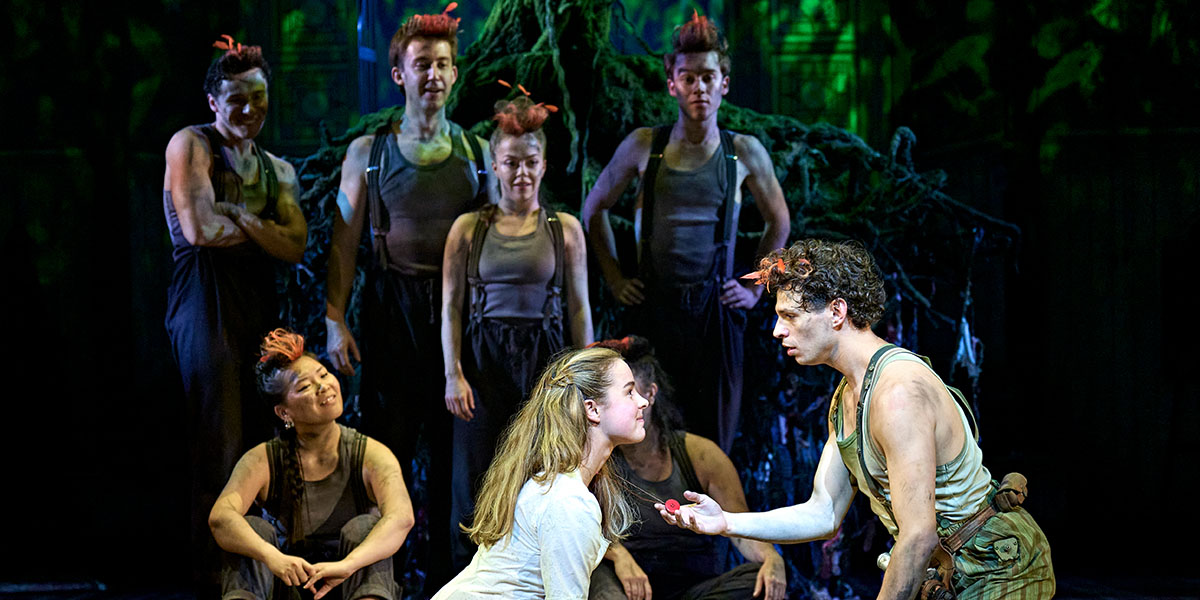 Wendy and Peter Pan are flying together against a starry night sky, with a soft glow illuminating their faces.