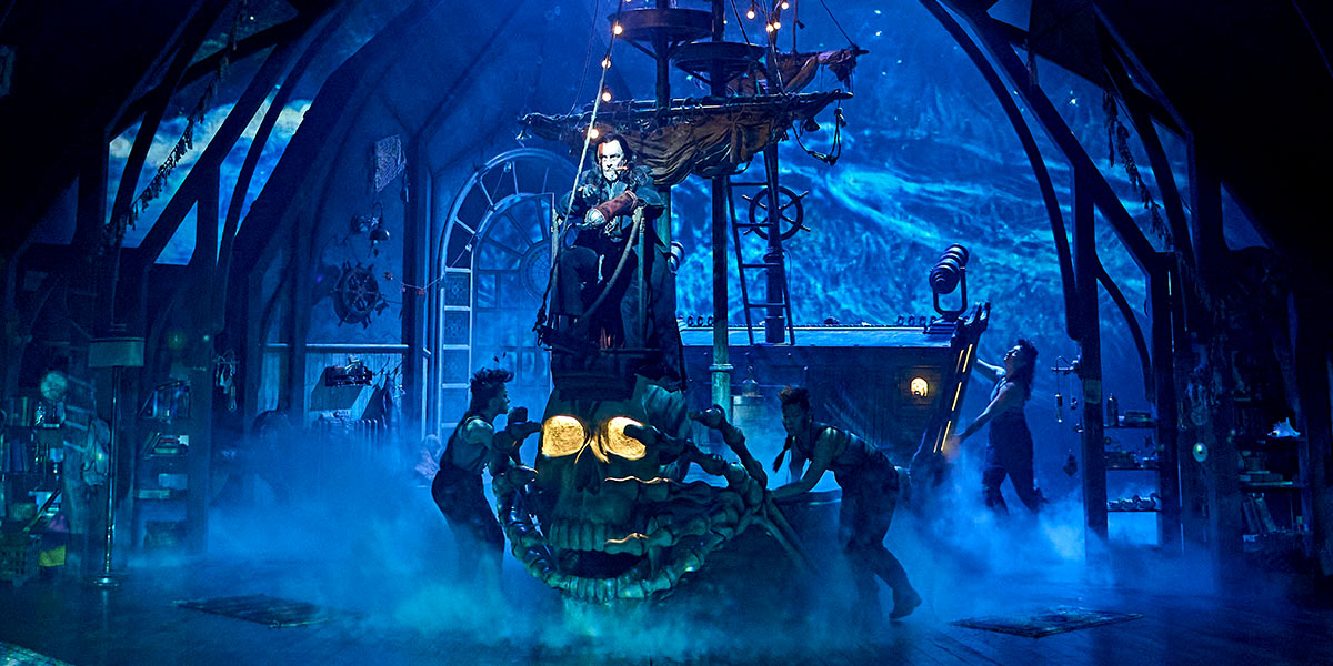 Wendy and Peter Pan are flying together, surrounded by a starry night sky and soft clouds.