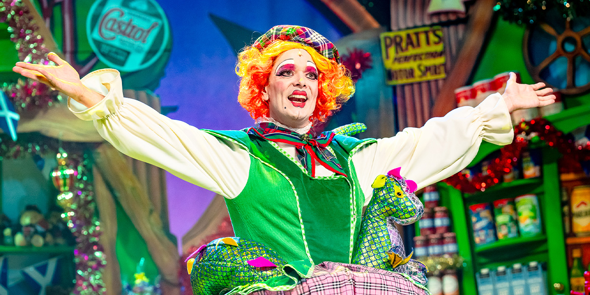 Matthew Baldwin as a character in Beauty and the Beast, wearing a detailed costume, surrounded by a theatrical set.