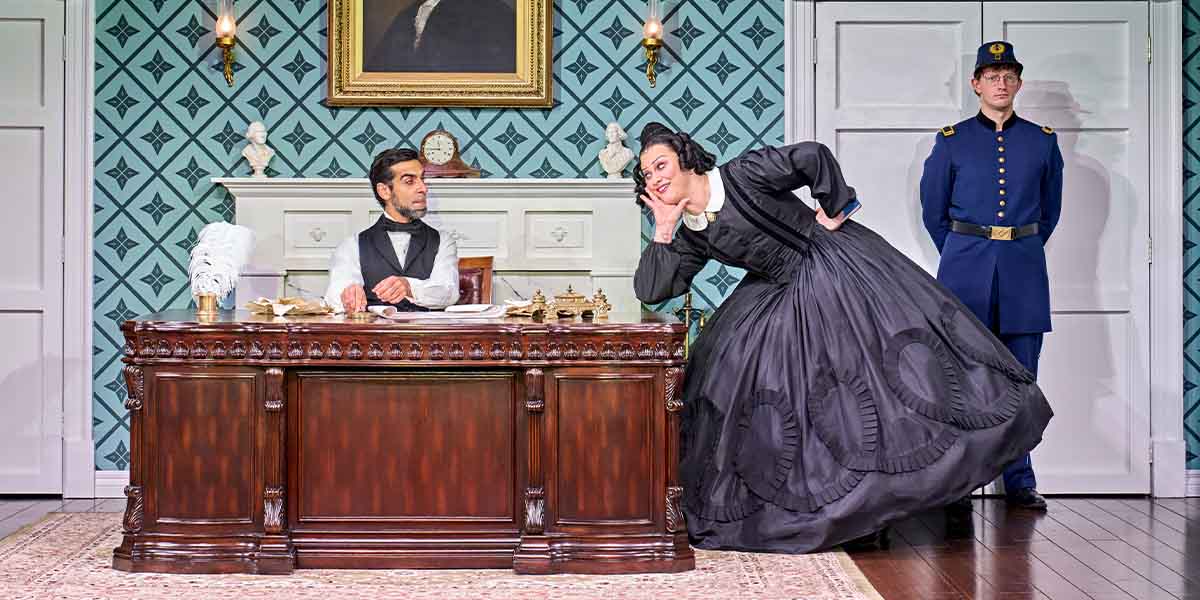 Scott Karim, Jinkx Monsoon as Mary Todd Lincoln, and Oliver Stockley pose together, smiling.