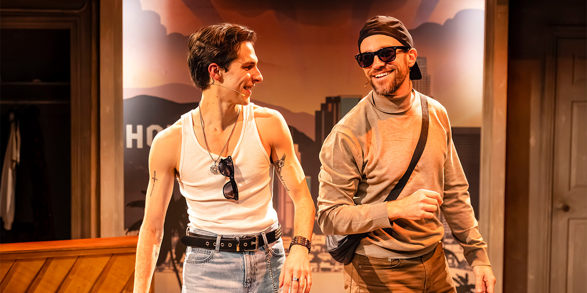 Killian Thomas Lefevre and Iffy Mizrahi pose together, smiling, against a blurred outdoor background.