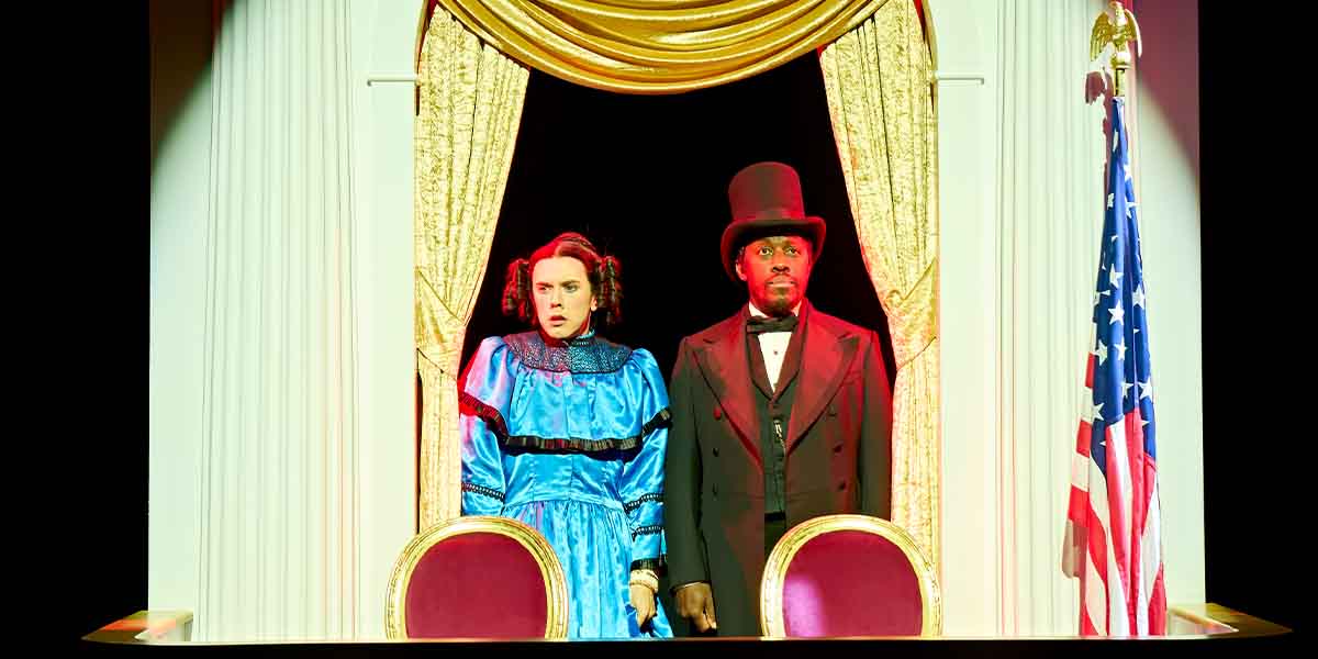 Cole Escola as Mary Todd Lincoln and Giles Terera as her husband, both in period costumes, looking concerned.