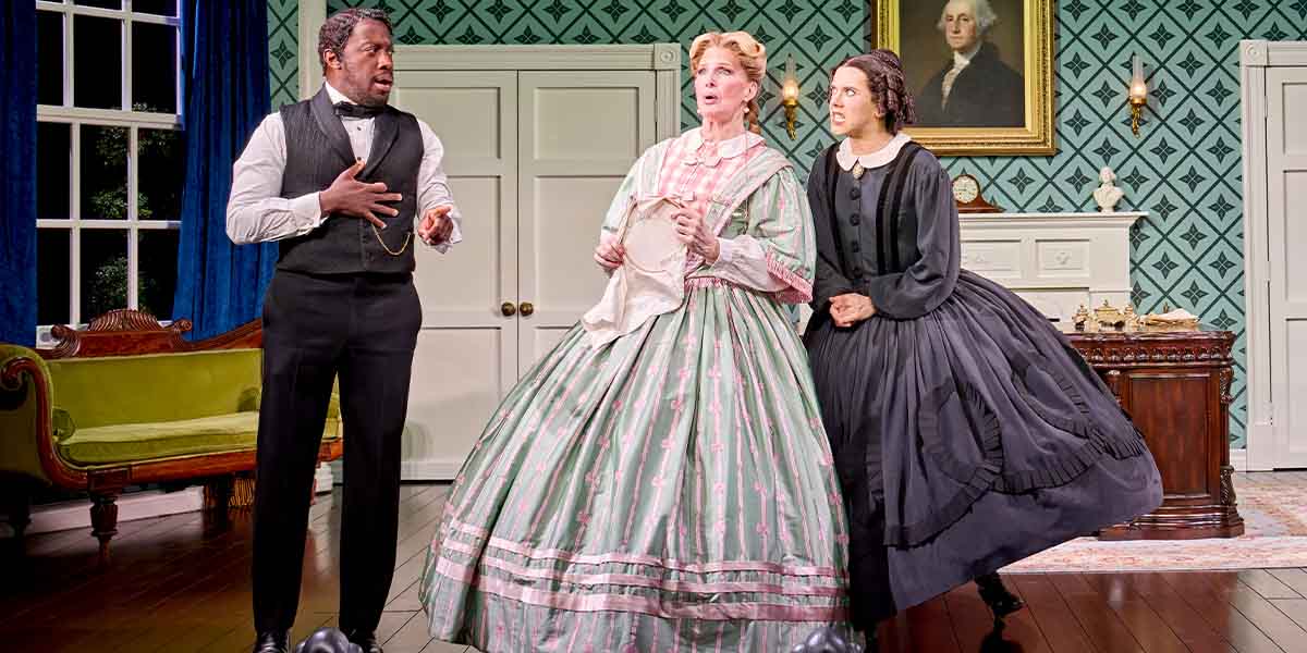 Giles Terera, Bianca Leigh, and Cole Escola perform in period costumes against a decorated interior backdrop.