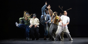 A vibrant street dance performance at Breakin' Convention, featuring dancers in dynamic poses against a colourful backdrop.