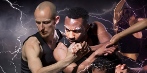 Shobana Jeyasingh performs a contemporary dance, showcasing fluid movements in a vibrant, textured costume against a dark background.