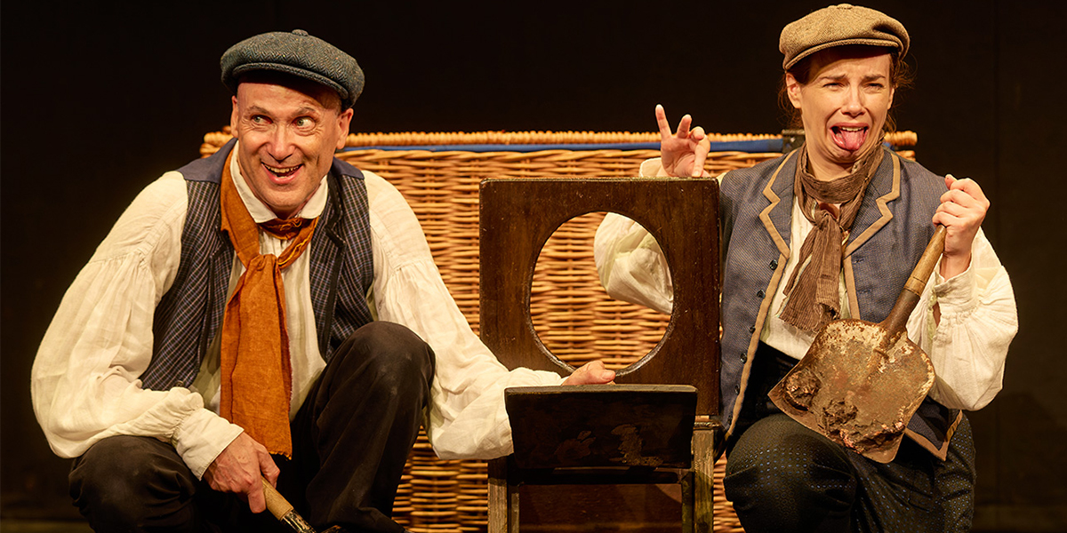 Children in historical costumes perform a scene from "Horrible Histories: Barmy Britain" on stage.