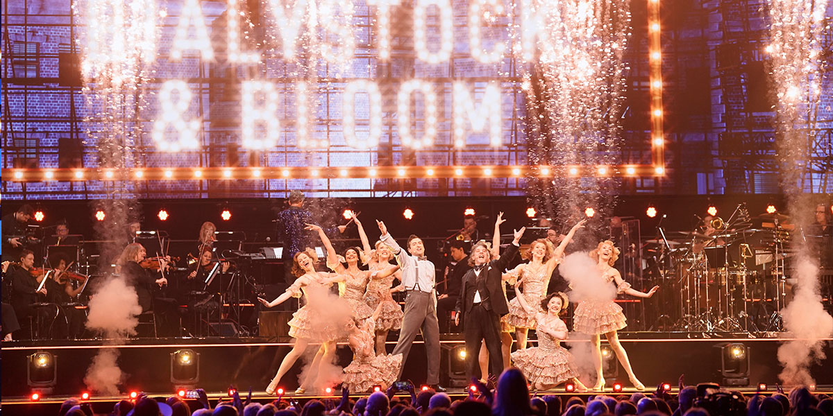 The cast of The Producers performing on an arena stage