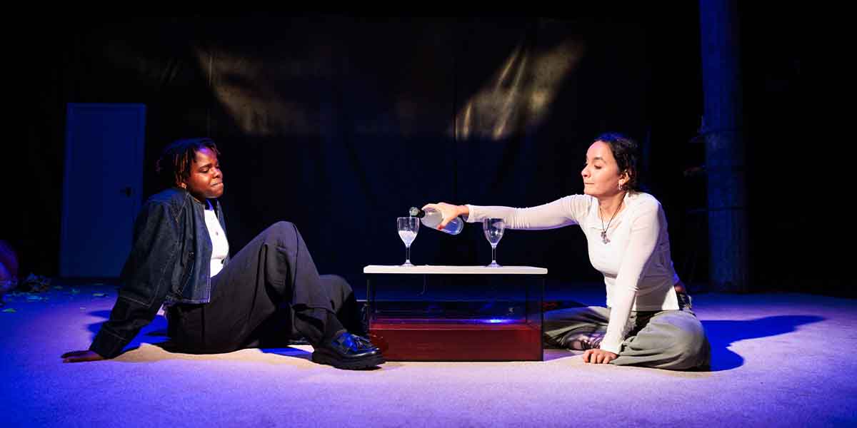 Francesca Amewudah-Rivers and Nadi Kemp-Sayfi perform in 'Tender', pouring drinks at a table.