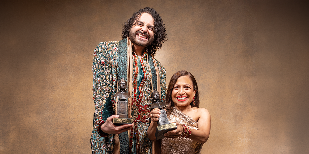 James and Arti smile proudly, holding their Olivier Awards against a neutral background.