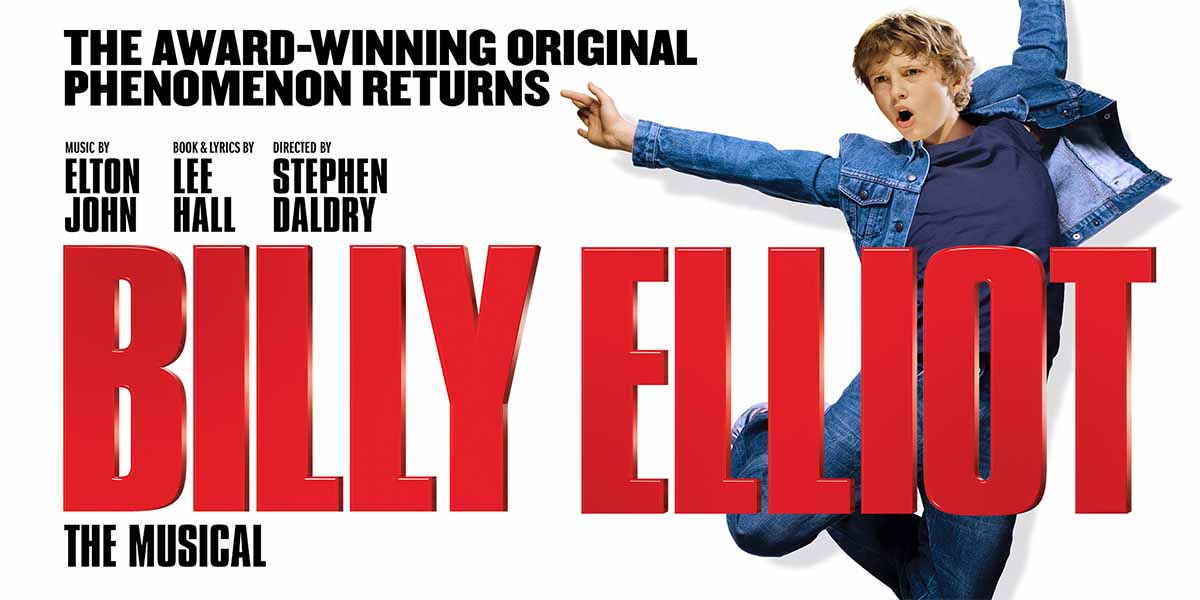 A young boy in a denim jacket strikes a dynamic pose, with bold text reading "BILLY ELLIOT.