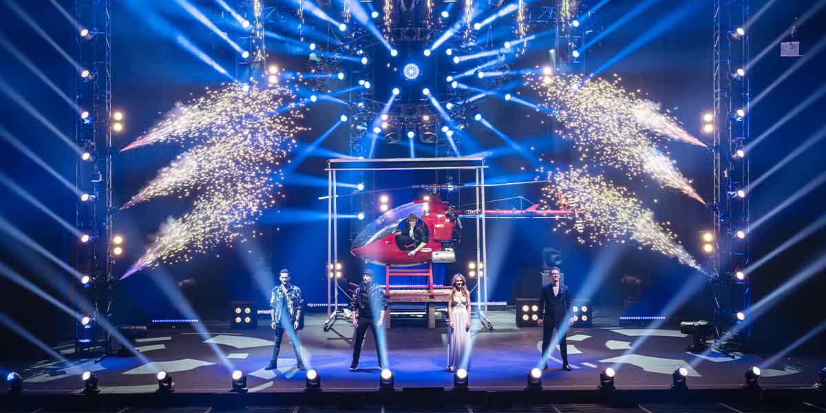 Enzo Weyne, Andrew Basso, Rafferty Coope, Gabriella Lester, and Matthew Pomeroy perform on stage with a helicopter.