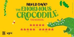 A vibrant stage scene from "The Enormous Crocodile The Musical" featuring colourful costumes and dramatic lighting.