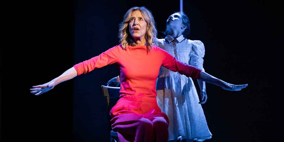 A person in a red outfit sits on a chair, arms outstretched, while a child in white looms behind.