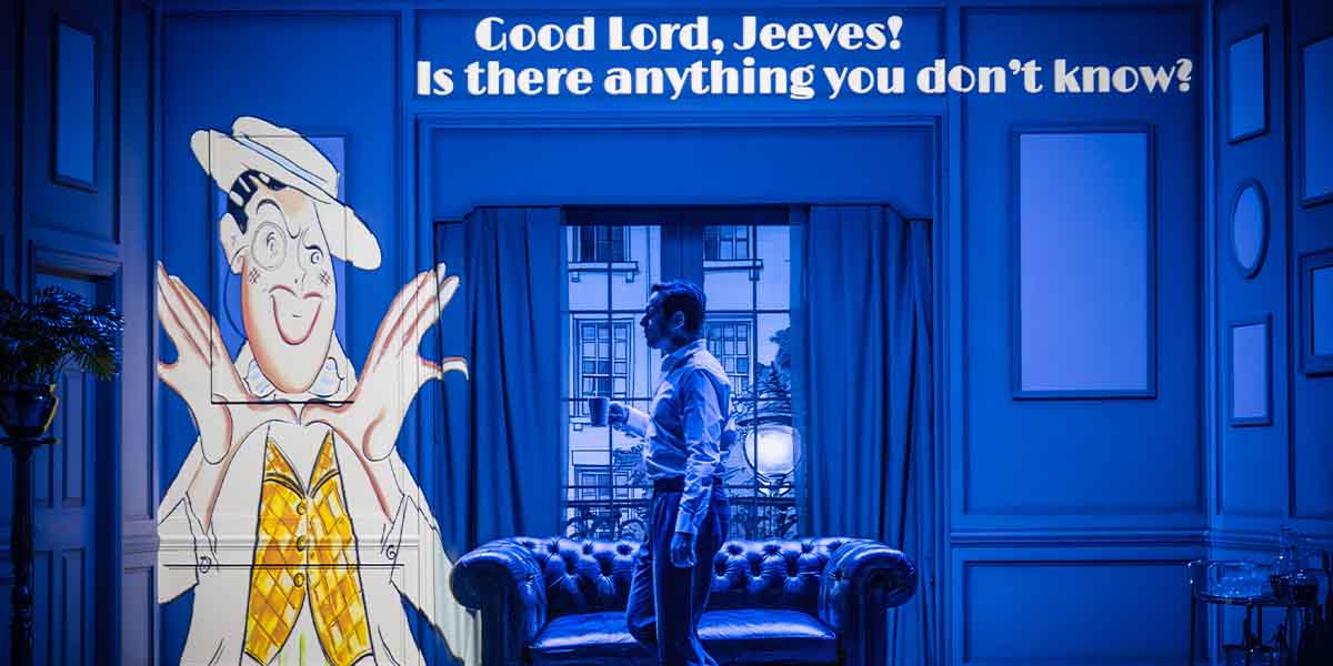 A man in a white shirt stands with a drink, looking at a large cartoon of Jeeves.