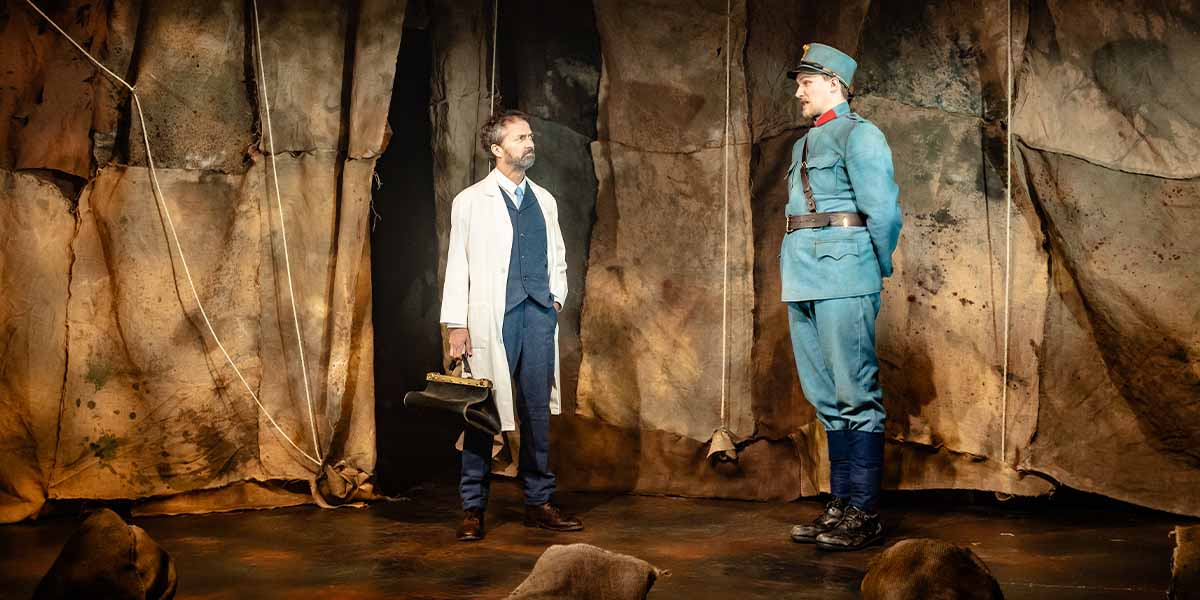 A man in a white coat holds a briefcase, facing a soldier in a blue uniform against a textured backdrop.
